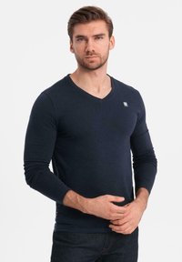 T-shirt a maniche lunghe blu navy con scollo a V realizzato in tessuto morbido, con un piccolo logo sul petto e un design slim e aderente.