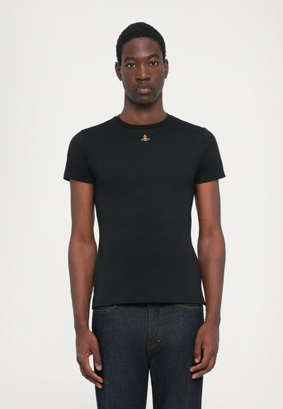 Tricou scurt negru, din bumbac, cu un grafic brodat mic și colorat aproape de decolteu. Design ajustat, textură netedă.