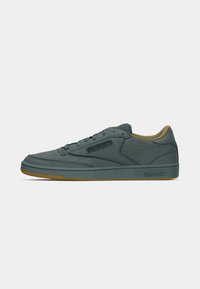 Boční pohled na tyrkysové tenisky Reebok s gumovou podrážkou, šněrovacím designem a polstrovaným límcem na jednobarevném světlém pozadí.