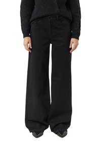 Czarne dzwony o szerokich nogawkach z fakturowanym wykończeniem, z subtelnym wzorem w kropeczki, przednimi kieszeniami i standardowym pasem.