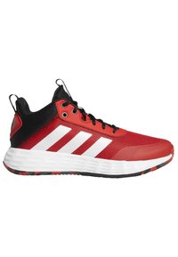 Zapatilla deportiva roja con acentos negros, parte superior de malla, diseño de tres rayas blancas y suela de goma texturizada que presenta un patrón de banda multicolor.