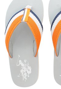Harmaat flip-flopit, joissa on oranssit, valkoiset ja laivastonsiniset raidalliset nailonihihnat sekä sileä kumipohja. Sisältää valkoisen polo-pelaajan grafiikan pohjallissa.