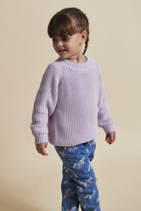 Pulover tricotat de culoare mov deschis, cu guler rotund, asortat cu blugi albaștri cu un model de unicorni în culori pastelate.