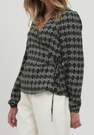Blouse noire et blanche à motifs avec un design drapé, manches longues bouffantes et lien ajustable à la taille. Tissu léger avec une texture lisse.