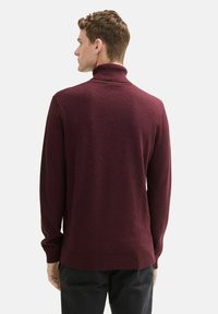 Burgundowy sweter golfowy z miękkiego materiału, z długimi rękawami i prążkowanym kołnierzem. Gładka faktura z dopasowanym krojem.