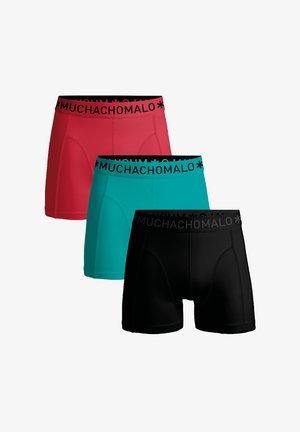 Trzy pary męskich bokserek: czerwone, turkusowe i czarne. Każda z nich ma czarną gumkę z napisem "MUCHACHO MALO" w białym kolorze. Gładka tekstura, sportowy design.