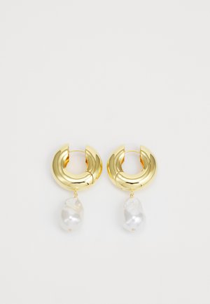 Orecchini a cerchio tono oro con una finitura lucida, caratterizzati da un accento in perla bianca irregolare sospesa. Design circolare, superficie liscia.
