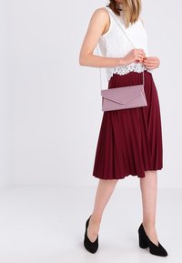 Lichtpaars clutch tasje met een gevouwen flap, gemaakt van glad synthetisch materiaal. Voorzien van een zilveren schouderriem voor crossbody gebruik.