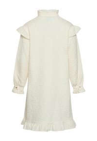 Valge tekstuuriga kleit kõrge kaelusega, volangdetailidega õlgadel ja pikkade varrukatega. Omab nööpidega mansette ja volangiga alusserva.