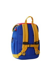 Zils mugursoma ar dzeltenām siksnām un akcentiem. Ir augšējais rokturis, polsterētas muguras daļa, sānu kabata un sarkana vilnas oderēta augšdaļa.