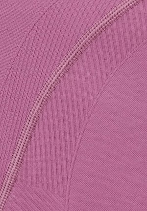 Close-up van roze stof met verschillende geweven texturen en een opvallend gebogen naadstiksel.