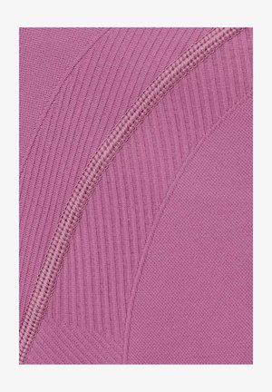 Close-up van roze stof met verschillende geweven texturen en een opvallend gebogen naadstiksel.