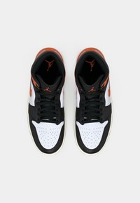 Hochschnittige Sportschuhe in einem Schwarz-, Weiß- und Orangeton mit perforierter Zehenkappe, schwarzen Schnürsenkeln und Jordan-Branding auf der Zunge.