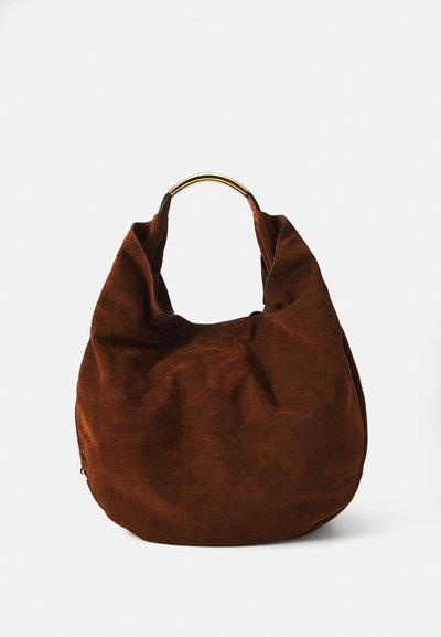 Brun ruskinds hobo bag med et slouchy design og et buet guldtonet metalhåndtag, der har en glat tekstur og minimale syninger.