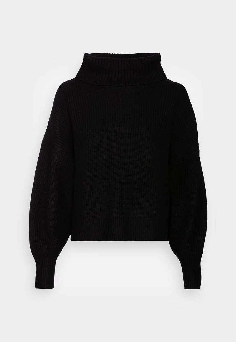 Pull en maille côtelée noire avec manches longues surdimensionnées et large col montant sur un fond gris clair.