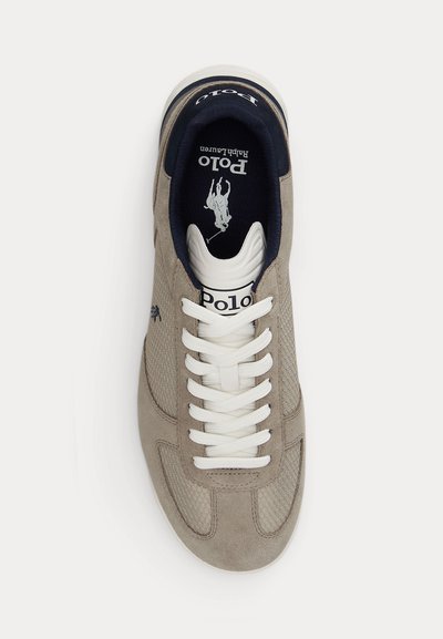 Μπεζ και λευκό sneaker Polo Ralph Lauren με λευκά κορδόνια, μαύρη εσωτερική επένδυση και λογότυπο Polo στη γλώσσα και στη σόλα.
