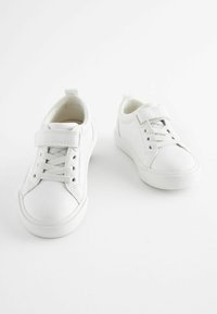 Hvide sneakers med en glat syntetisk overdel, rund tå, snørebåndslukning og en velcrolukning på siden for ekstra justerbarhed.
