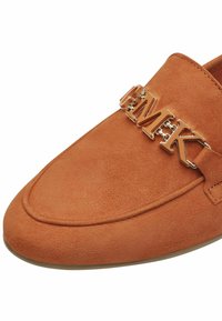 Oranje suede loafers met een ronde neus, voorzien van een glanzende goudkleurige kettingaccent met letters aan de voorkant. Glad oppervlak overal.