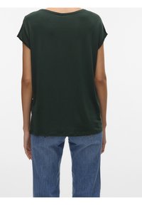 Ciemnozielony top z krótkim rękawem o luźnym kroju, okrągłym dekolcie i gładkiej fakturze, w połączeniu z jasnoniebieskimi jeansami z wysokim stanem.