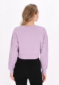 Lavendelkleurige cropped sweatshirt met lange mouwen, geribbelde manchetten en een ronde halslijn. Heeft een gladde textuur en subtiele randdetails.