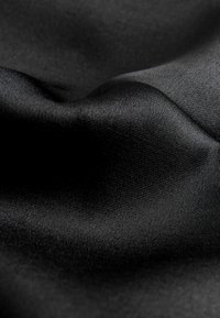 Schwarzer Satin-Stoff mit glatter Textur und leichtem Glanz, der dezente Falten und ein einheitliches Oberflächenmuster aufweist.