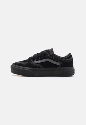 Czarny niskoprofilowy sneaker z grubą podeszwą, szarym paskiem po boku, czarnymi sznurowadłami i szczegółowym przeszyciem na jednolitym jasnym tle.
