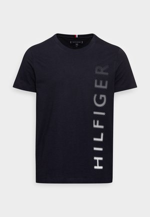 Czarny T-shirt z krótkim rękawem i okrągłym dekoltem, z pionowym nadrukiem "HILFIGER" białymi, kropkowymi literami po prawej stronie.