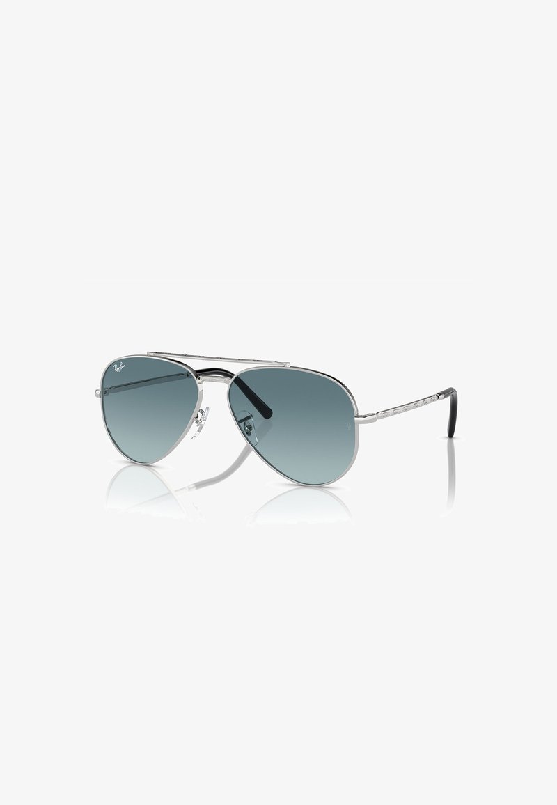 Occhiali da sole Ray-Ban aviator con montatura metallica argentata, lenti grigie sfumate e punte nere sulle aste. Presentano un design a doppio ponte.