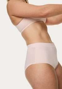 Sous-vêtements taille haute de couleur rose clair fabriqués en tissu doux, avec une taille lisse et un design sans coutures. Idéaux pour un port quotidien.