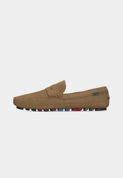 Mocassin en daim marron clair avec détails cousus, bride à monnaie et semelle en caoutchouc multicolore, sur fond uni.