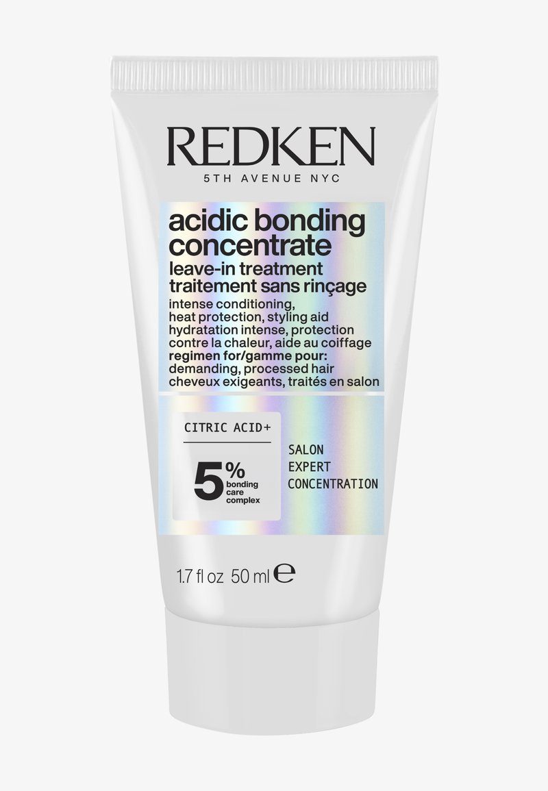Redken leave-in behandeling in een witte tube van 50 ml. Bevat vetgedrukte zwarte tekst, holografische accenten en labels voor productgebruik en ingrediënten.