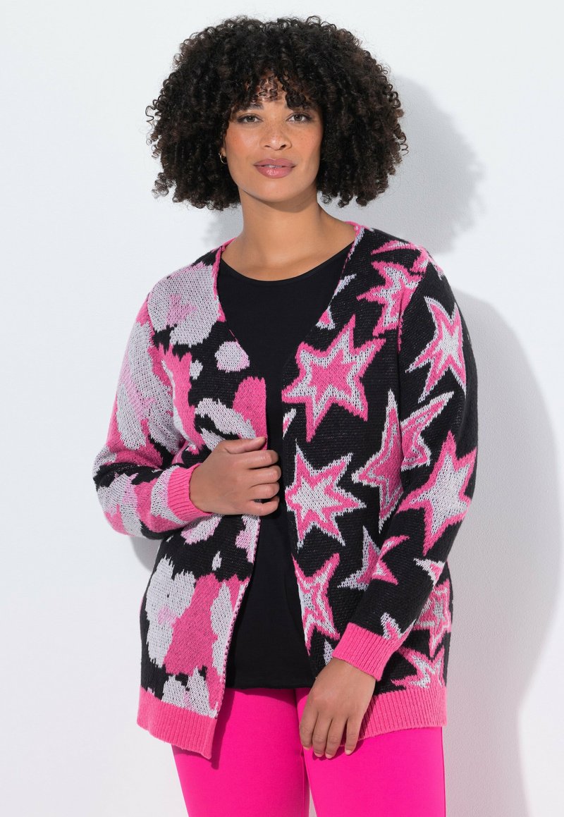Cardigan mit schwarzem Hintergrund, der mit rosa und weißen Sternen sowie floralen Mustern verziert ist. Stricktextur mit rosa gerippten Bündchen und Saum.