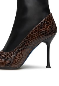 Scarpa con tacco alto in pelle nera e stampa pitone marrone, con punta affusolata, caratterizzata da una silhouette elegante e un design con tacco a stiletto.