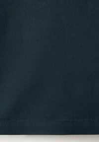 Dunkel marineblauer Stoff mit sichtbarer Naht entlang der unteren Kante, zeigt Textur- und Webdetails.