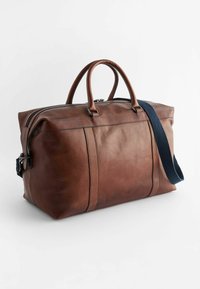 Brun läder weekendväska med texturerad yta, dubbla handtag, avtagbar blå axelrem och dragkedjestängning. Rektangulär form med markerade sömmar.