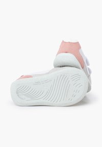 Zapatillas blancas y rosa pastel con correas de velcro, suela de goma texturizada, forma redondeada y suaves acentos de ante.
