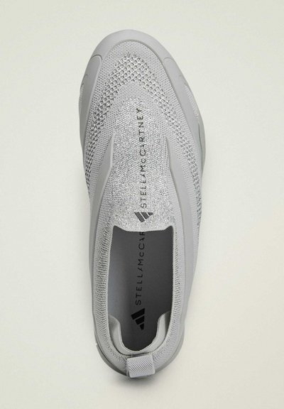 Baskets à enfiler gris clair avec tige en tricot, motif texturé, et marquage "Stella McCartney" sur la semelle intérieure et la zone de la languette.