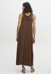 Robe maxi sans manches marron avec un détail en crochet texturé au niveau du col, tissu léger et silouhette fluide.