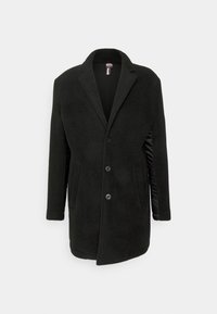 Manteau noir en mélange de laine avec un devant boutonné, un col en pointe, des poches latérales et des panneaux latéraux lisses en satin. Texture douce, coupe ajustée.