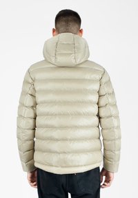 Beige pufferjakke med horisontal quiltet design, hætte og skinnende overflade. Har elastisk kant og ærmer for en tæt pasform.