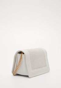 White leather clutch bag with a textured front panel, gold chain strap, and a structured shape, featuring stitched detailing around the edges.
