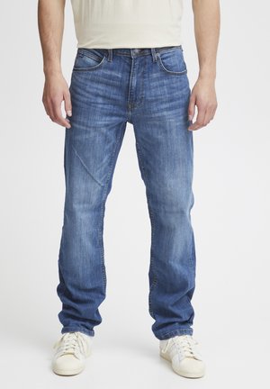 Blå denimjeans med rak benklipp, ljusa blekningar och klassisk femfickdesign. Bärs med vita sneakers, visad framifrån.