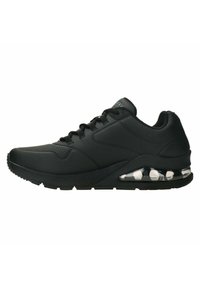 Sneaker nera con una parte superiore in sintetico liscio, dettagli testurizzati e collo imbottito. Ammortizzazione ad aria trasparente visibile nella suola. Design con lacci.