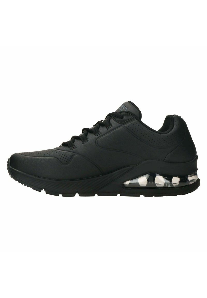 Sneaker nera con una parte superiore in sintetico liscio, dettagli testurizzati e collo imbottito. Ammortizzazione ad aria trasparente visibile nella suola. Design con lacci.