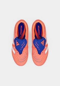 Botas de fútbol de color naranja brillante con un acento azul, que cuentan con una parte superior texturizada, un diseño aerodinámico y detalles blancos en los laterales.