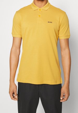 Gelbes Poloshirt mit kurzen Ärmeln, einem spitzen Kragen, einer Drei-Knopf-Leiste und einem dezenten schwarzen "BOSS"-Logo auf der Brust.