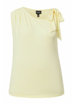 Blusa sin mangas de color amarillo pálido con un hombro fruncido y anudado en un lazo en el lado izquierdo.