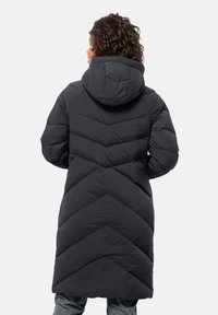 Black puffer coat with a hood, featuring a chevron quilted design, knee-length cut, and a smooth texture.