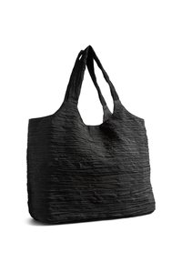 Sac fourre-tout texturé noir avec de larges doubles poignées, structure souple et surface du tissu légèrement froissée.