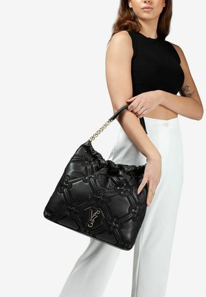 Borsa nera in ecopelle con motivo floreale trapuntato, dettagli in metallo dorato e manico a catena. Presenta una chiusura con coulisse.